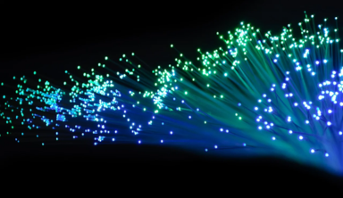 Close‑up of glowing fibre optic cable ends representing high‑speed leased line network connectivity.